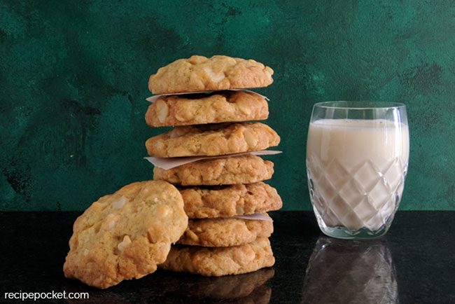 White chocolate macadamia nut cookies with a glass of milk.
