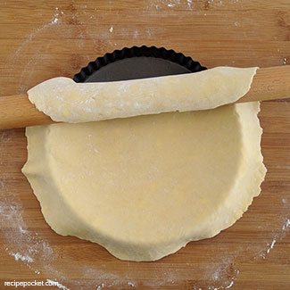 Use the rolling pin to lift the dough onto the baking tin.