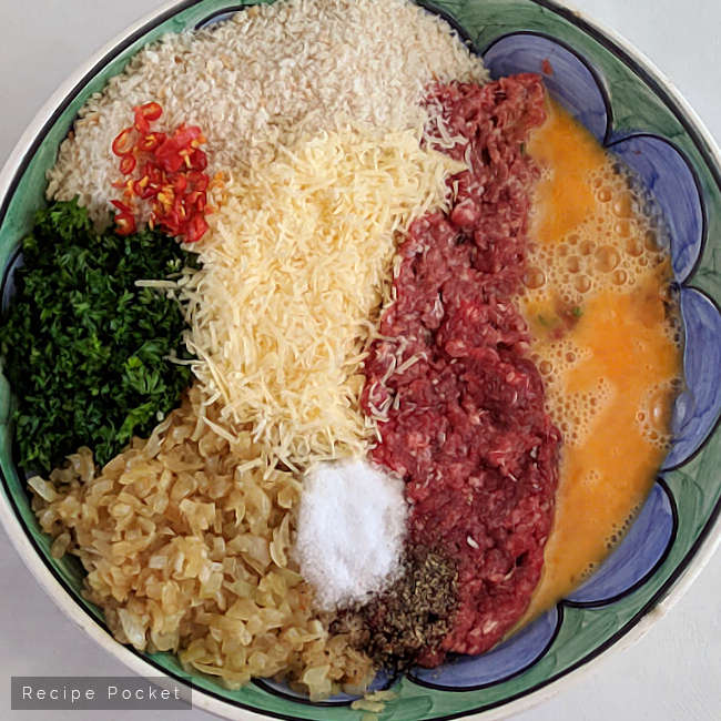 Bowl with ingredients to make beef meatballs.