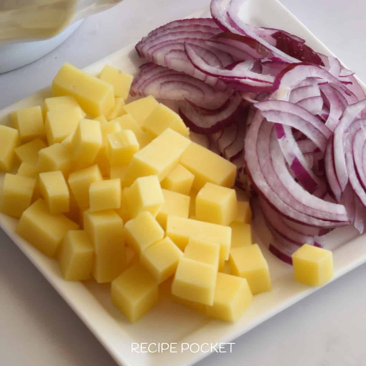 Cubed cheese and slices of red onion.