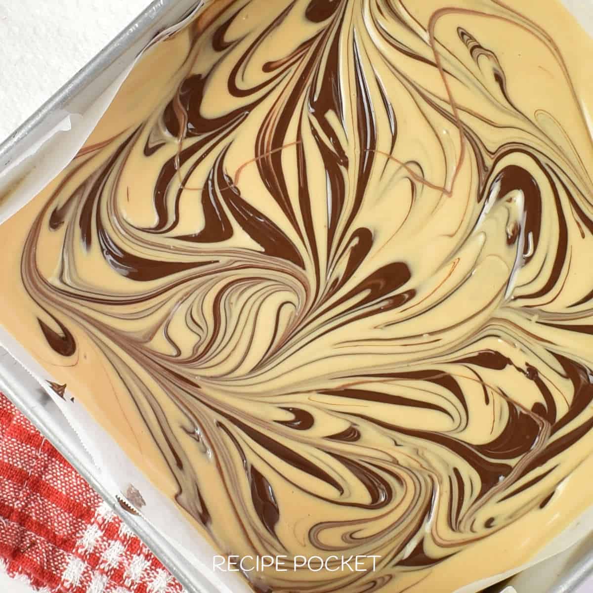 Dark chocolate swirls in a white chocolate and peanut butter mixture.