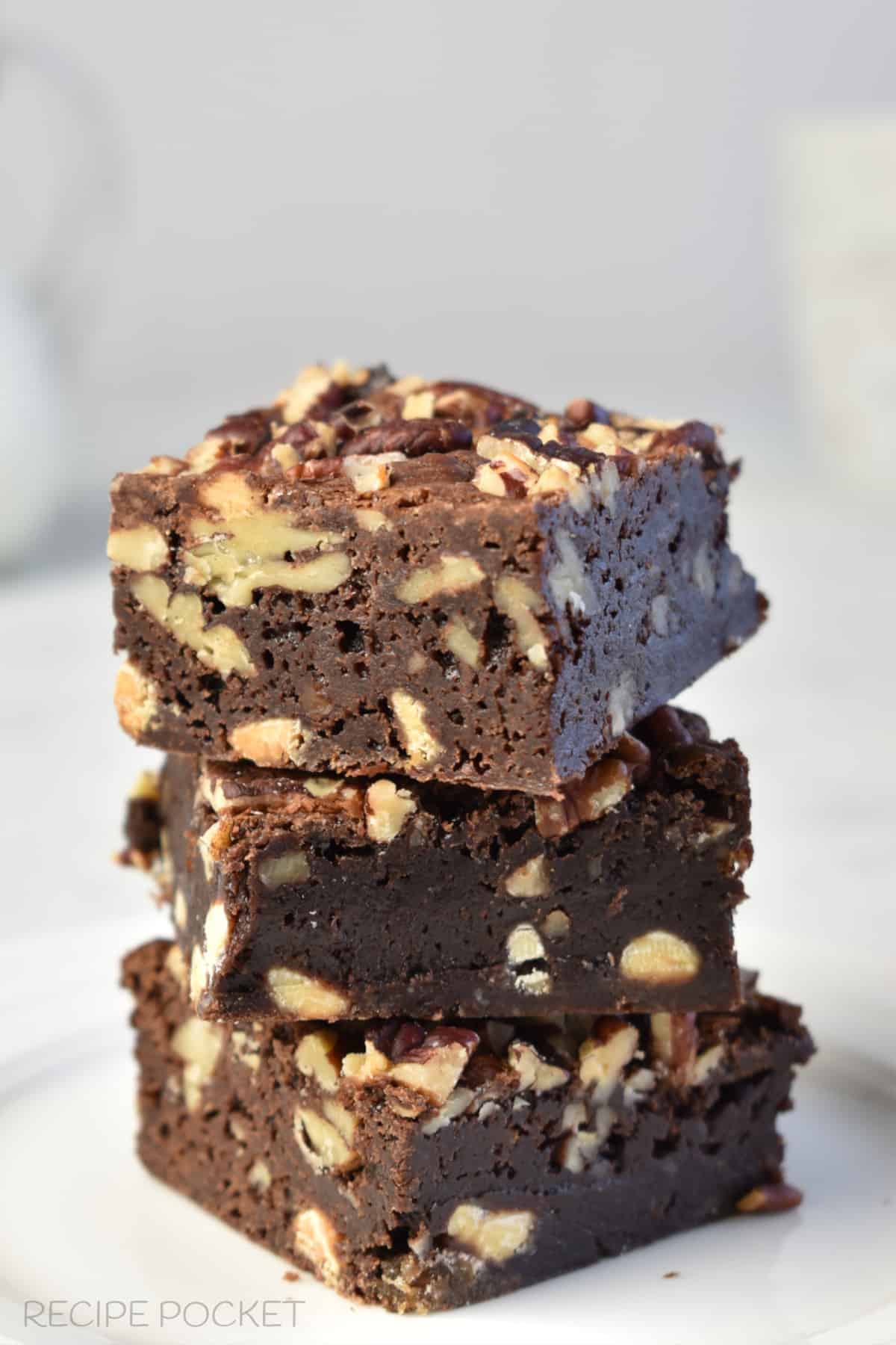 A closeup of three brownies stacked on top of each other.