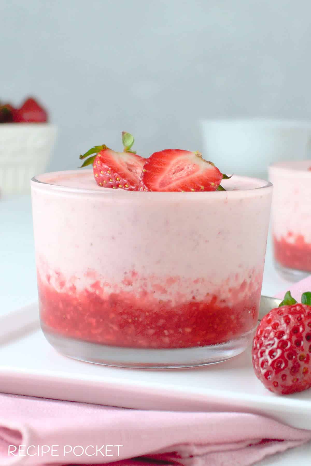 Strawberry fool on a white plate garnished with fresh strawberries.