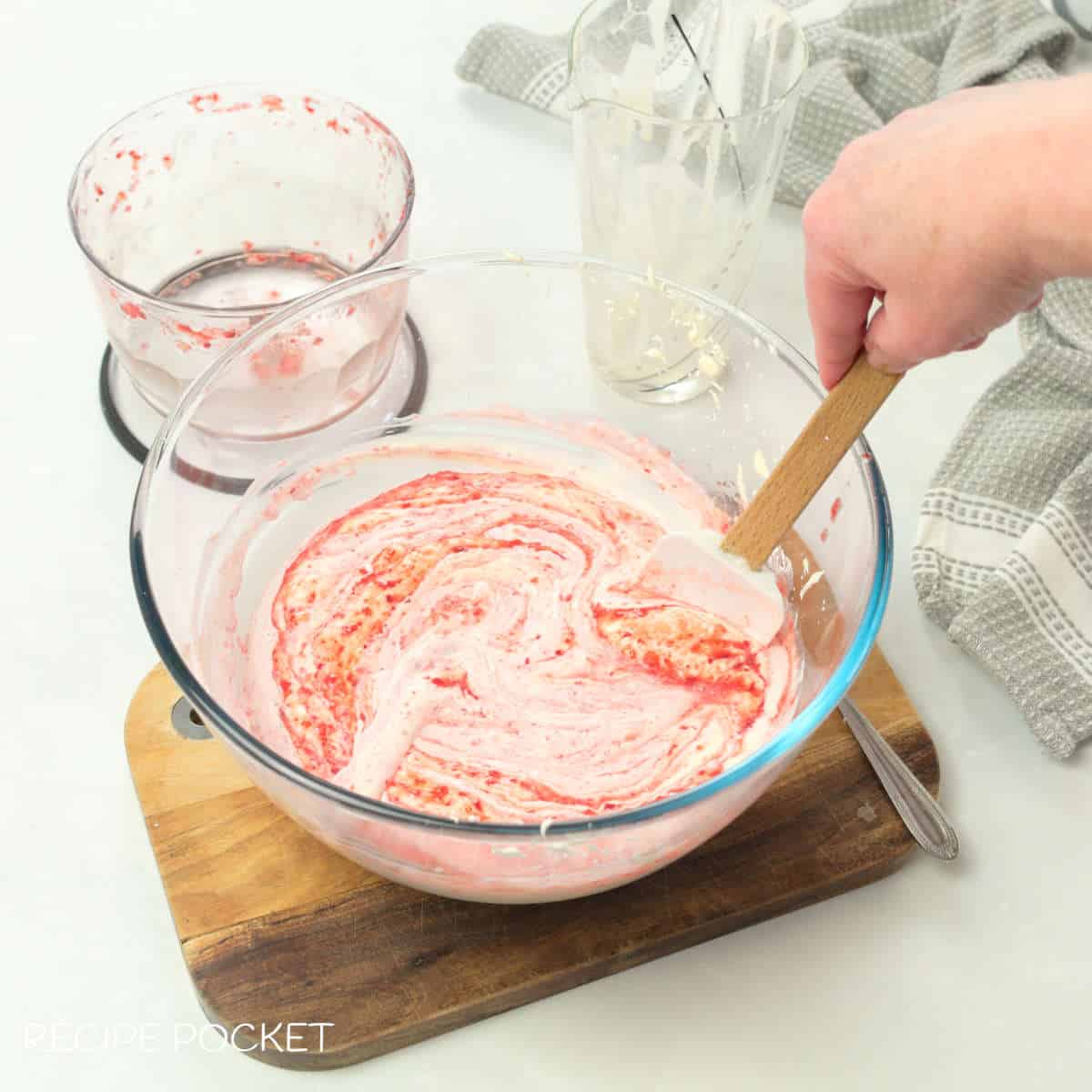 Strawberry puree and whipped cream in a bowl.