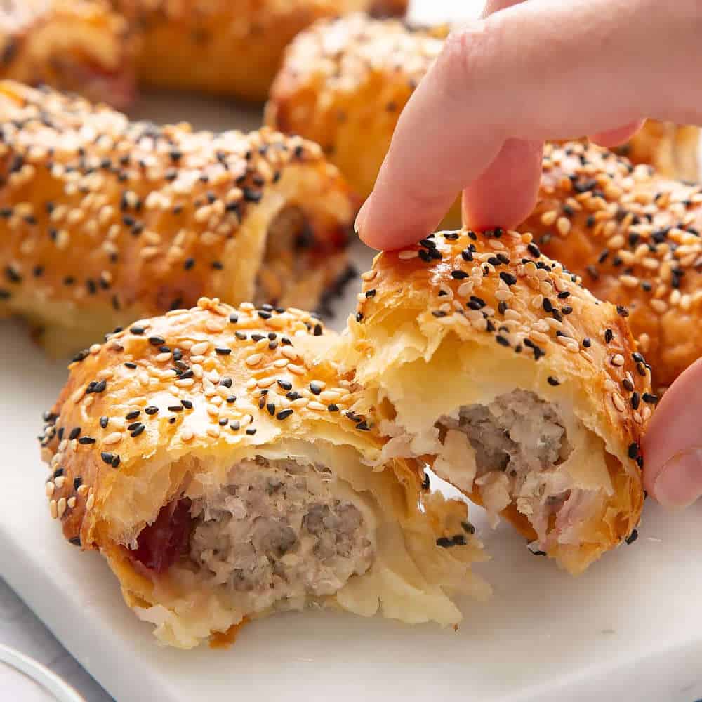 Sausage rolls with black and white sesame seeds.