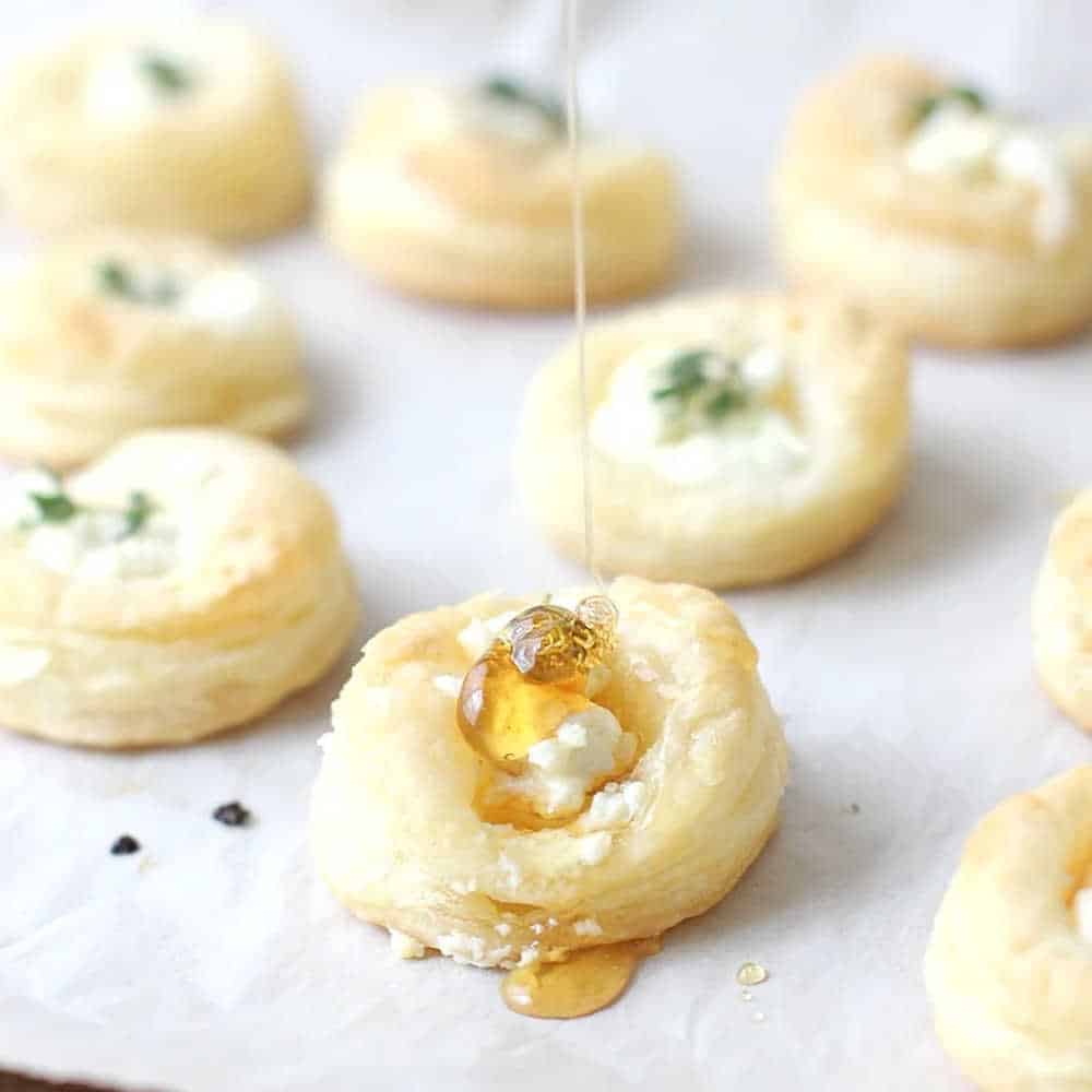 Puff pastry cases filled with cheese with a drizzle of honey on top.