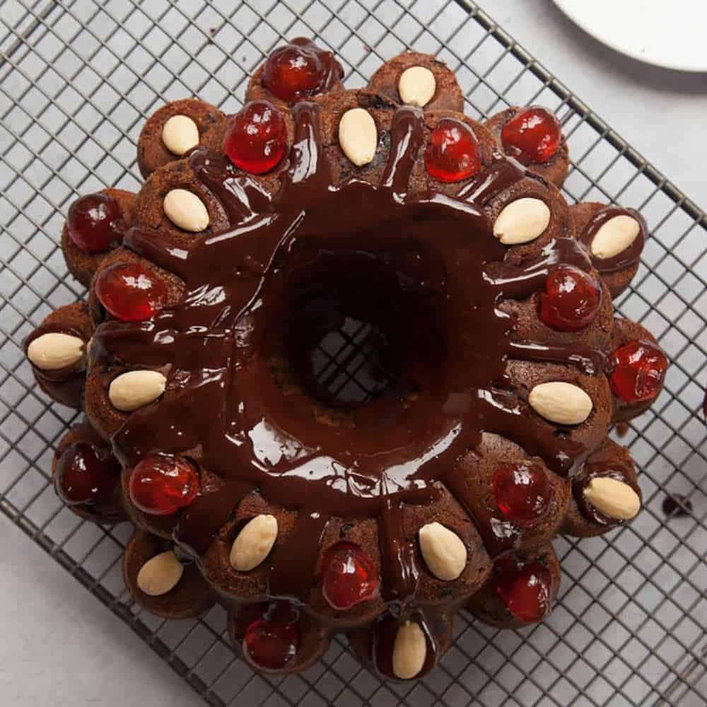 Chocolate bundt cake with almond and cherry decorations.