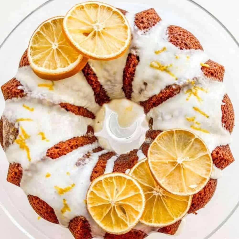 Top down view of a cake decorated with icing and orange slices.
