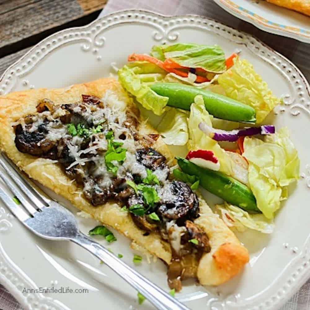 Crescent dough triangles topped with mushrooms with a salad on the side.