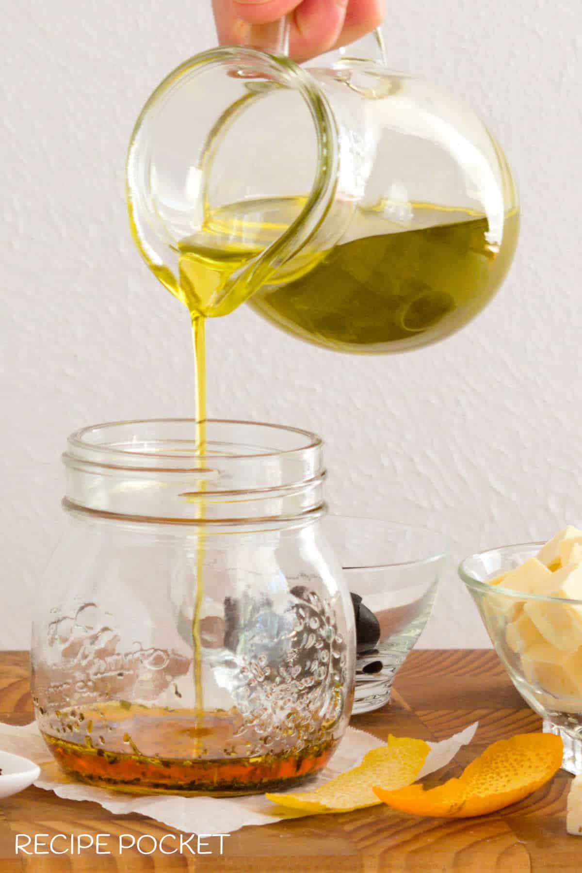 Olive oil poured into a glass jar.