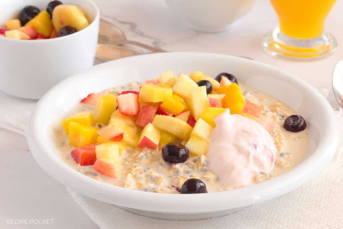 Overnight oats with a fruit salad and yogurt topping.