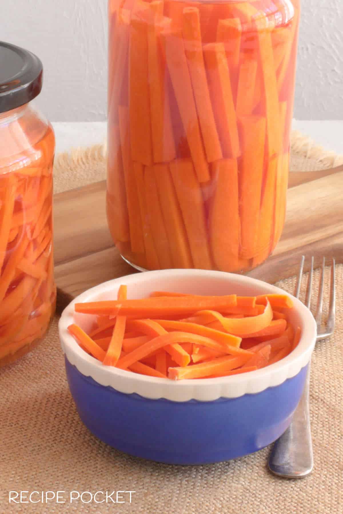 Closeup of carrot pickle in a small blue bowl.