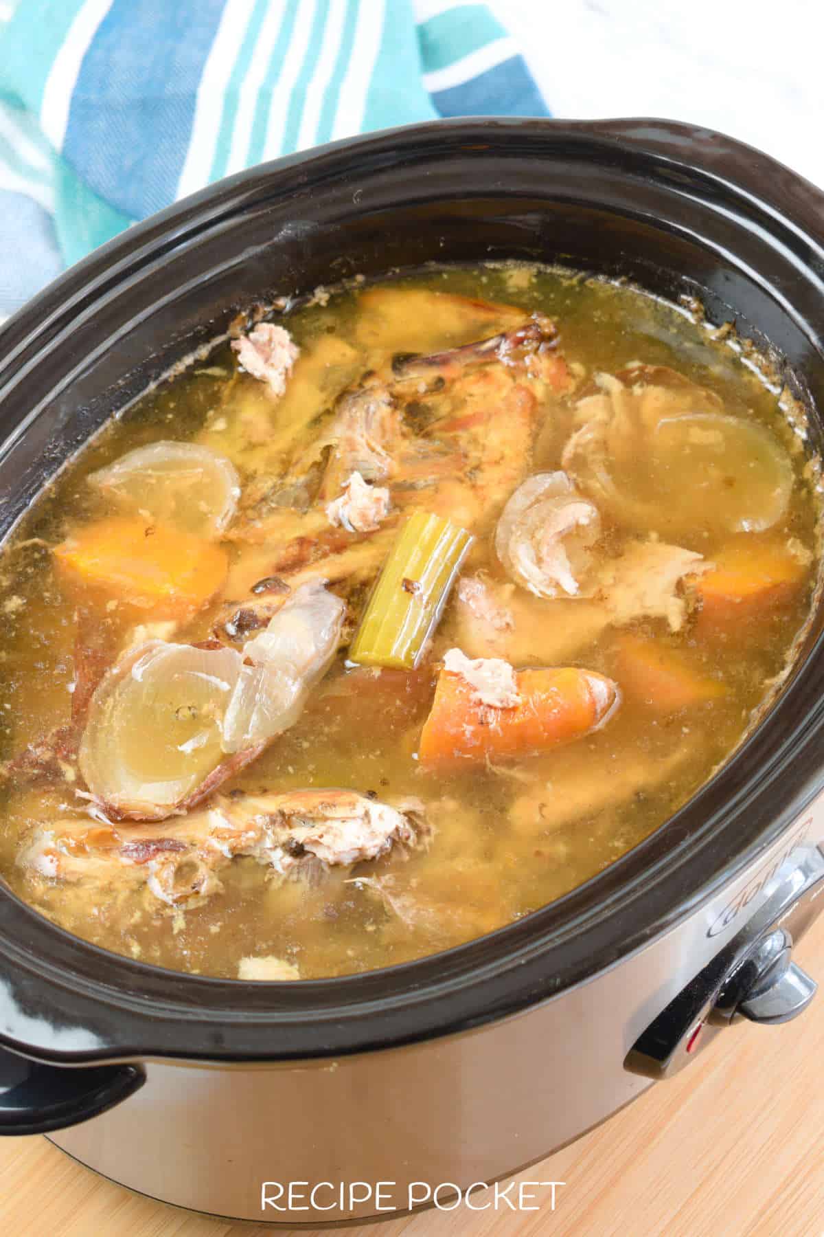 Close up of chicken broth in a slow cooker.