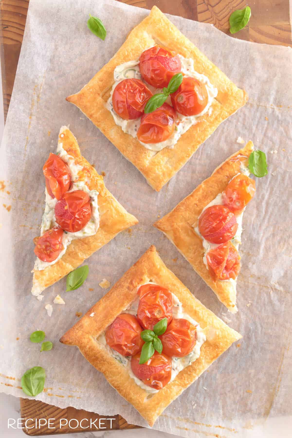 A top down view of puff pastry tartlets with cherry tomatoes.