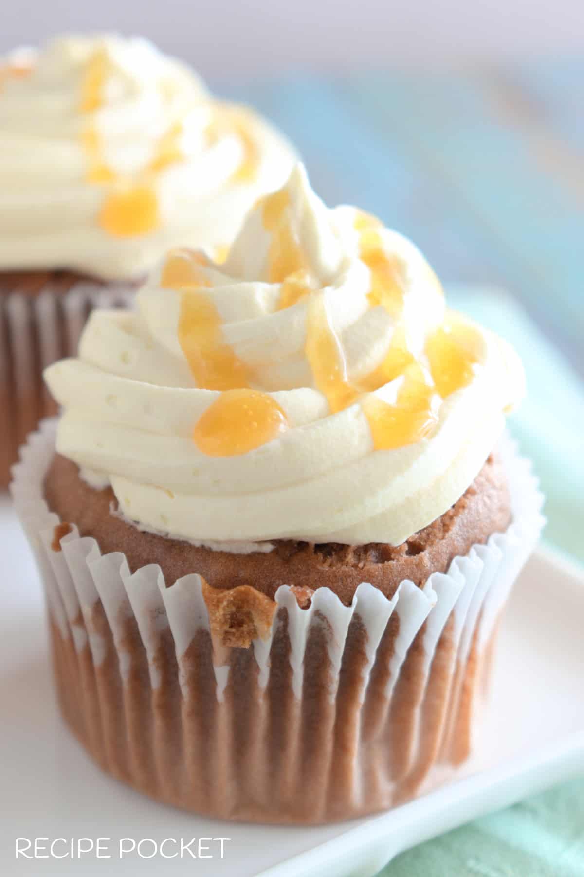 Cupcakes with whipped cream topping and caramel drizzle.
