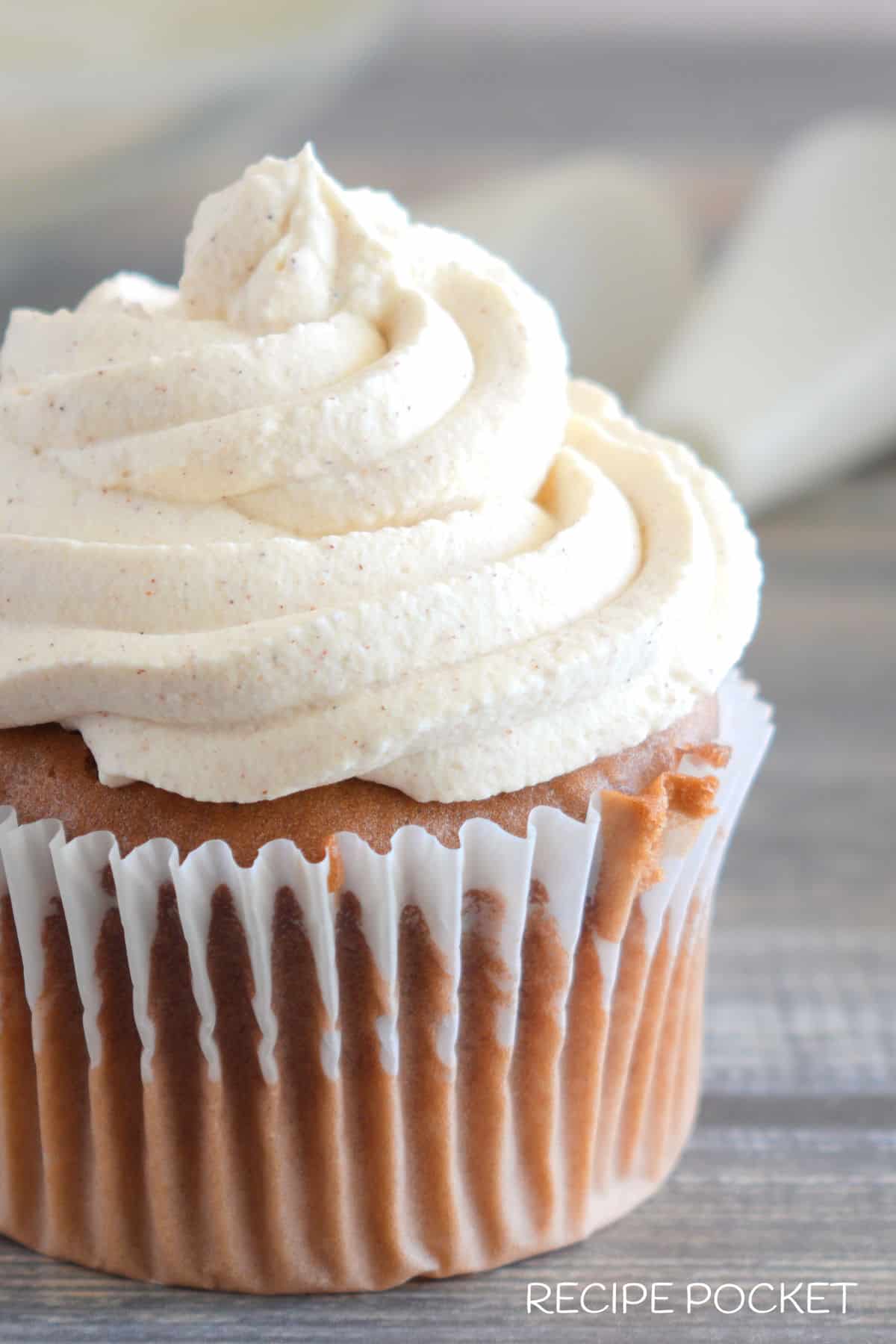 A close up view of cinnamon whipped cream on a cupcake.