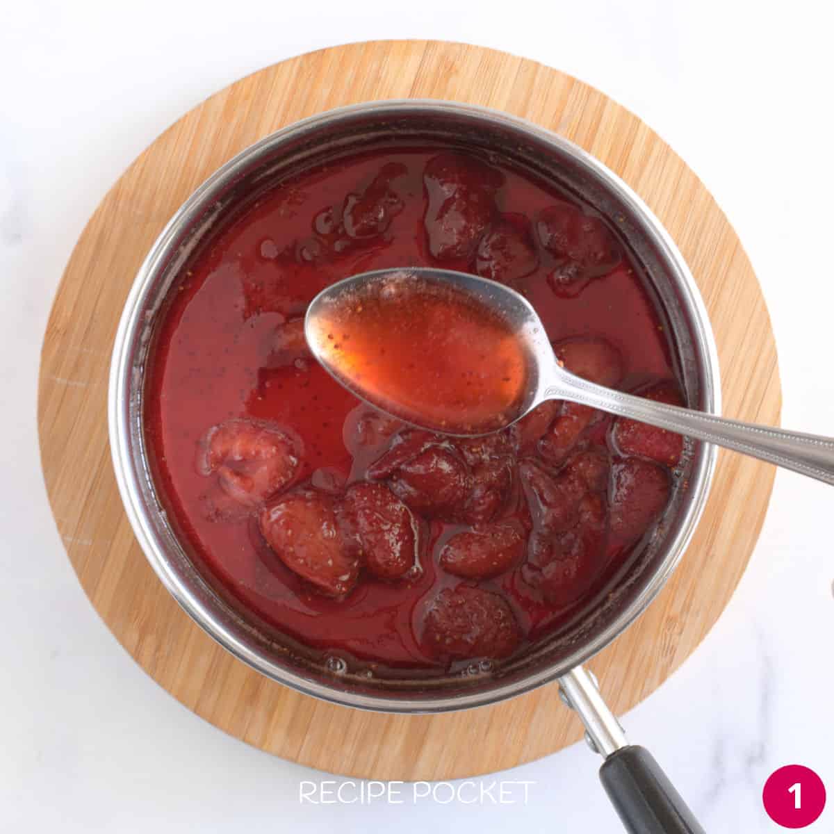 Cooked strawberries in syrup in a saucepan.